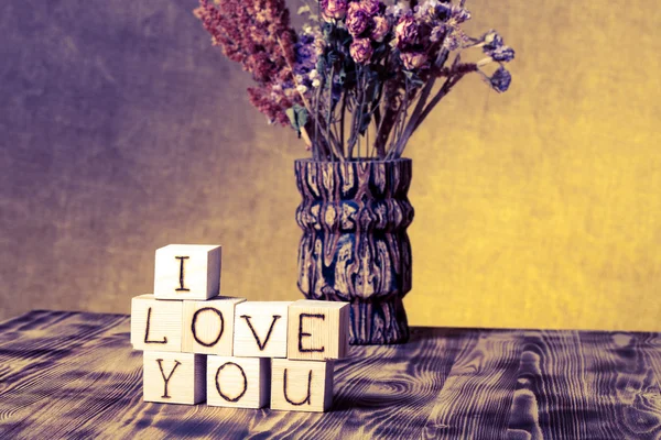 Houten kubussen met inscriptie "I Love You" en boeket van droge fl — Stockfoto