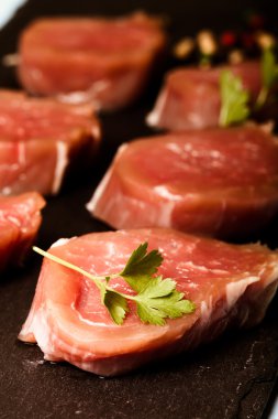 Otlar ve baharatlar mavi üzerinde siyah arduvaz tabakta çiğ et 