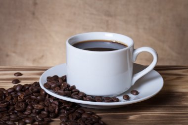 Kahve çekirdekleri ve ahşap masa ters beyaz fincan kahve bir 
