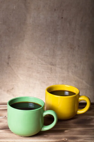 Kaffee in Tasse auf Holztisch gegenüber einem defokussierten Büschel — Stockfoto
