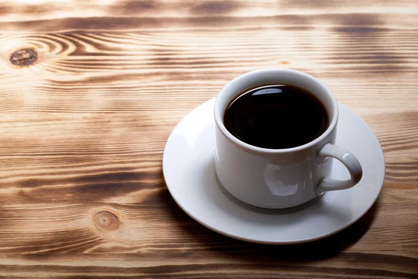 Café na xícara na mesa de madeira clara — Fotografia de Stock