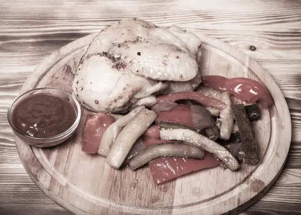 Poulet aux légumes servi sur planche à découper ronde sur brûlé — Photo