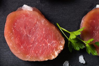 Otlar ve baharatlar siyah arduvaz tabakta çiğ et. Tonda