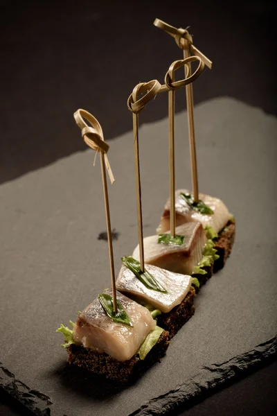 Piccolo snack tartina con aringhe, pane di segale, lattuga e verde o — Foto Stock