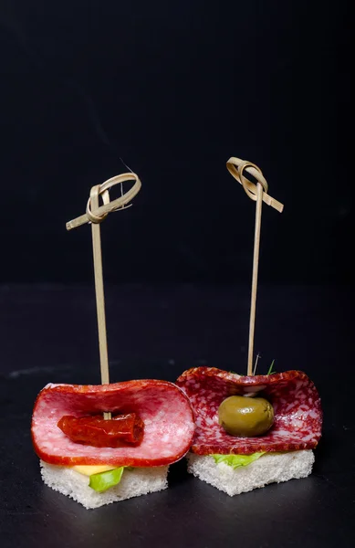 小さなスナック サラミ、パン、レタスの串のカナッペ — ストック写真