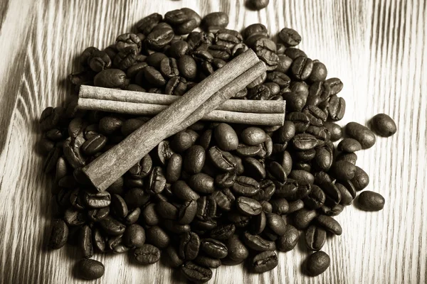 Montón de granos de café con canela en la mesa de madera para backgroun — Foto de Stock