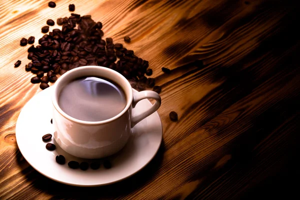 Kopi kacang dan kopi dalam cangkir putih di atas meja kayu. Selektif — Stok Foto
