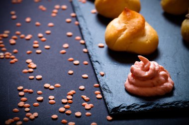 Siyah arduvaz tabakta küçük profiterol kümesi. Sığ derinlik 