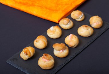 Siyah arduvaz tabakta küçük profiterol kümesi. Seçici focu