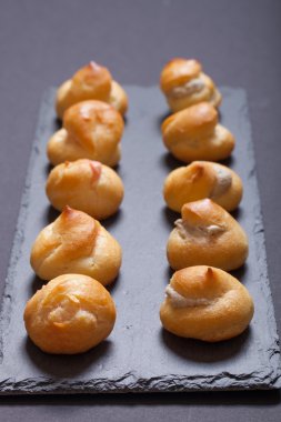 Siyah arduvaz tabakta küçük profiterol kümesi. Seçici focu