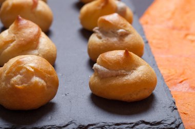 Siyah arduvaz tabakta küçük profiterol kümesi. Sığ derinlik 