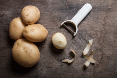 Eski ahşap arka plan üzerinde peeling ile patates