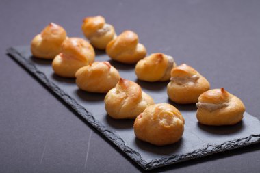 Siyah arduvaz tabakta küçük profiterol kümesi. Seçici focu