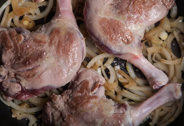 Entenkeulen in einer Pfanne mit Knoblauch und Zwiebeln gebraten — Stockfoto