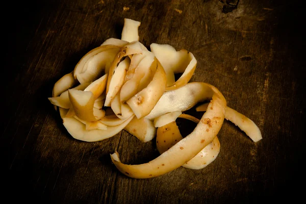 Bucce di patate su sfondo vecchio di legno. Tonica — Foto Stock