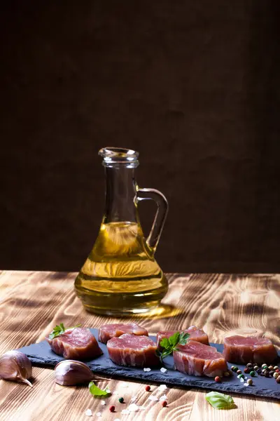 Carne cruda con hierbas y especias en un plato de pizarra negra sobre una lana —  Fotos de Stock