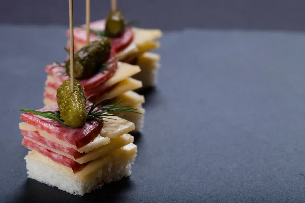 Små snacks KANAPE med salami, ost och ättikslag på spett på — Stockfoto