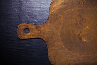 Siyah arka plan üzerine eski kesme tahtası. Tonda