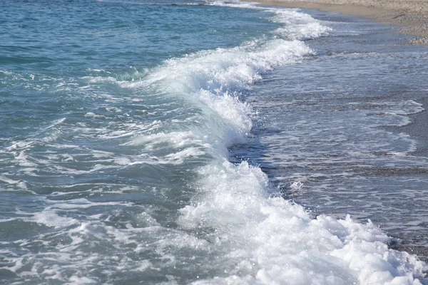 Ola en la costa de guijarros del mar. Enfoque selectivo — Foto de Stock