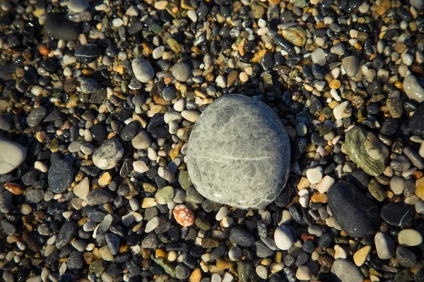 Sfondo di ciottoli naturali su una costa di mare. Concentrazione selettiva. Per — Foto Stock