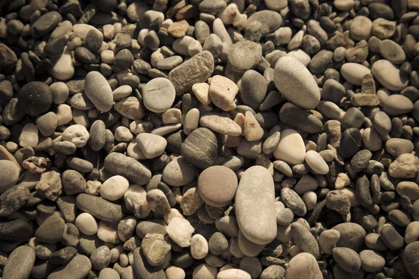 Sfondo di ciottoli naturali su una costa di mare. Concentrazione selettiva. Per — Foto Stock