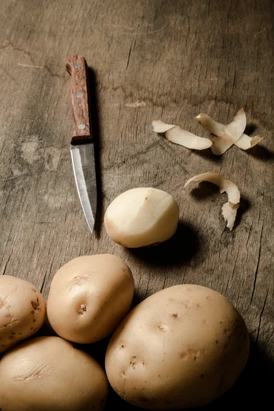 Картошка с кожурой на старом деревянном фоне. Toned — стоковое фото