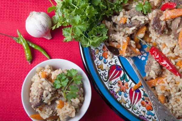 Hot delicious pilaf on a turkish plate on red striped tablecloth — Stock Photo, Image