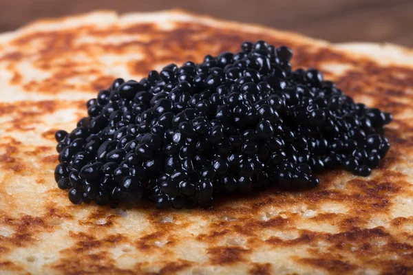 Black caviar on Russian pancakes - blini. Selective focus — Stock Photo, Image