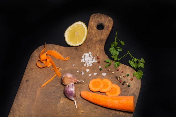 Salt, pepper and vegetables on old wood background — Stock Photo, Image