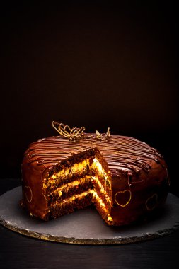 Çikolatalı kek siyah arka plan üzerine kayrak plaka üzerinde. Tonda