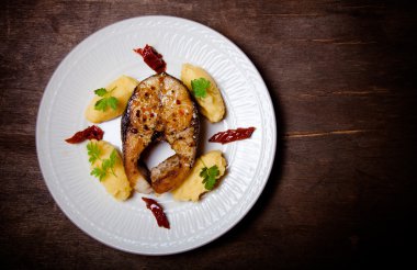 Kızartılmış ton balığı ile patates püresi, kurutulmuş domates ve maydanoz üzerinde 