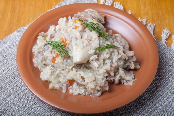 Arroz com frango em uma chapa de barro em guardanapo de linho — Fotografia de Stock