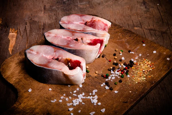 Tonno crudo e spezie per cucinare su un vecchio fondo di legno . — Foto Stock