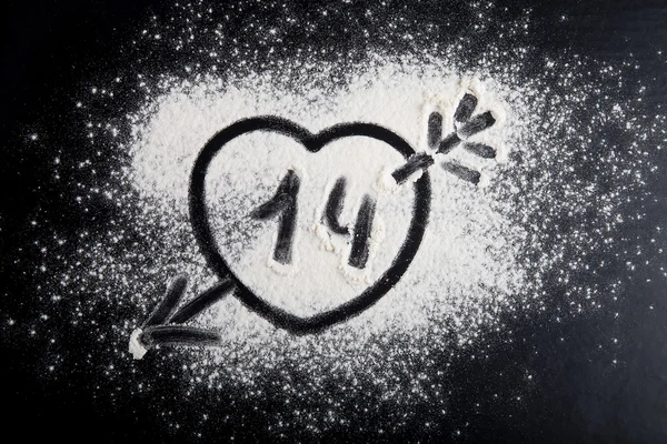 Forma de coração desenhado sobre a farinha em um fundo preto — Fotografia de Stock