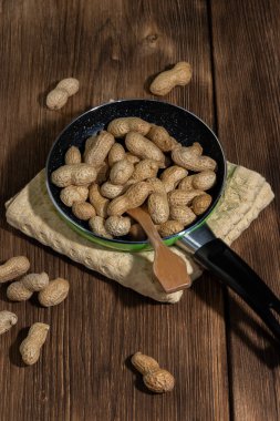 Leguminous bitkisi vitamin, antioksidan, demir, hemoglobin ve lif kaynağıdır. Ceviz, niasin B3 içerir. Ahşap bir arka planda, tavada kızartılmış fıstık vardır.