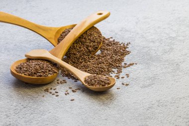 Beton zemindeki tahta kaşıkta keten tohumu, kolesterolü azaltan bir diyet ürünü, bir omega-3 kaynağı, B ve C vitaminleri, eser elementler, iyot, fosfor, potasyum, magnezyum, nikel