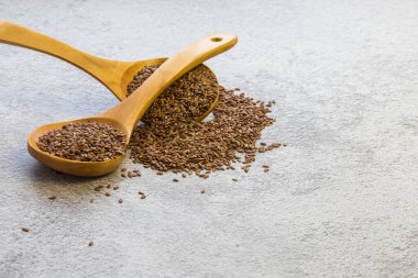 Beton zemindeki tahta kaşıkta keten tohumu, kolesterolü azaltan bir diyet ürünü, bir omega-3 kaynağı, B ve C vitaminleri, eser elementler, iyot, fosfor, potasyum, magnezyum, nikel