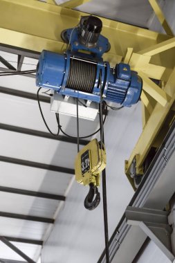 Elektrikli motoru olan turna kirişi endüstrisi ve kapalı alanda yük taşımak için büyük bir metal kanca.
