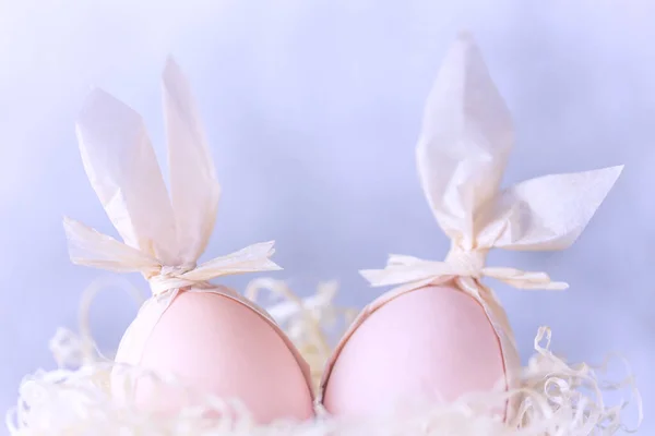 Wielkanoc twórcza. Dwa jajka z króliczymi uszami w gnieździe, pomysł na dekorację — Zdjęcie stockowe