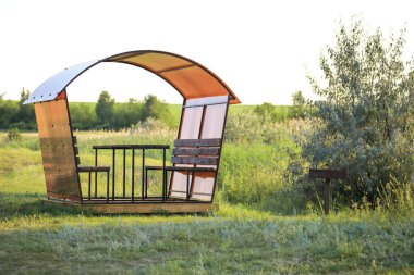 Barbekü masalı bir çardak ve yaz aylarında açık havada piknik için bank.