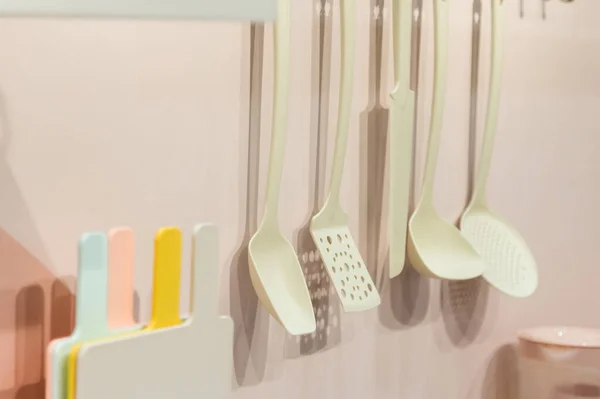 Köksredskap hushållsartiklar plast hänga på väggen, kök inredning i pastell trendiga färger — Stockfoto