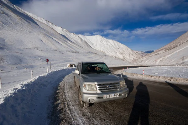 Gürcistan, Kazbek - 1 Aralık 2013: Soğuk bir kış gününde buzlu bir yolda araba.