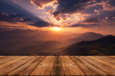 Yazın güzel arka planı, dağların üzerinde gün doğumu ve doğada boş ahşap masa. Doğal şablon manzarası.