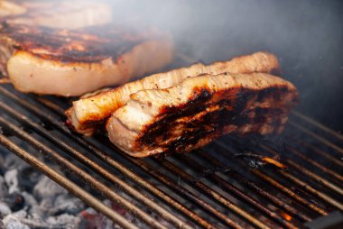 Yanan ızgarada ızgara biftek. Seçici odak ile çekim.