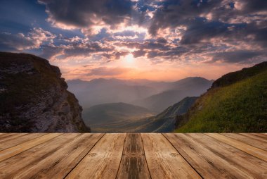 Yazın güzel arka planı, dağların üzerinde gün doğumu ve doğada boş ahşap masa. Doğal şablon manzarası.