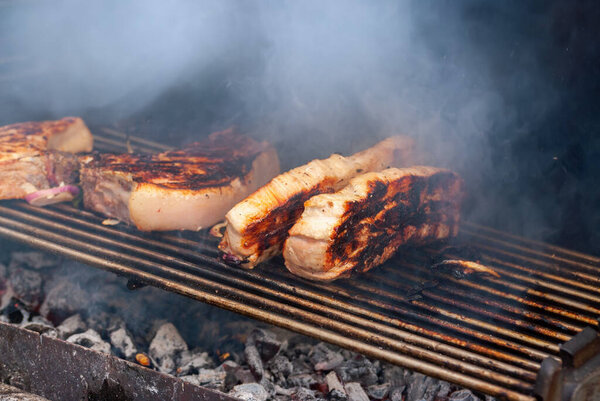 grilling steaks on flaming grill. shot with selective focus.