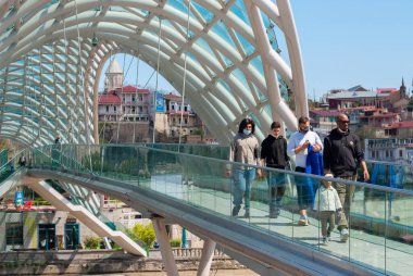 Gürcistan, Tiflis - 15 Nisan 2021: Tiflis 'teki Barış Köprüsü' nde insanlar yürüyor.
