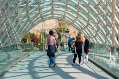 Gürcistan, Tiflis - 15 Nisan 2021: Tiflis 'teki Barış Köprüsü' nde insanlar yürüyor.