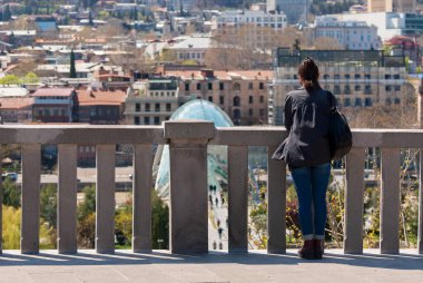 Gürcistan, Tiflis - 15 Nisan 2021: Güzel bir günde şehir manzarasının tadını çıkaran turistler.