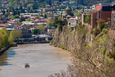 Gürcistan, Tiflis - 24 Nisan 2021: Turistler Mtkvari, Kura Nehri boyunca bir zevk gemisine biniyorlar.